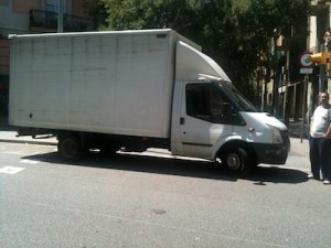 Foto on es veu un camió aparcat just al pas de vianants i el seu conductor al costat, mirant tranquilament com li faig la foto i com ens hem de desviar per a que poguem creuar el carrer amb un cotxet de nen