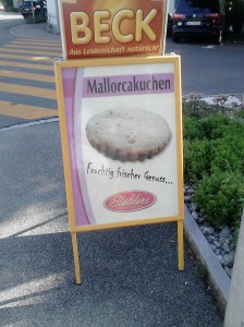 Cartell al carrer on s'anuncia una mena de reposteria amb la llegenda Mallorcakuchen