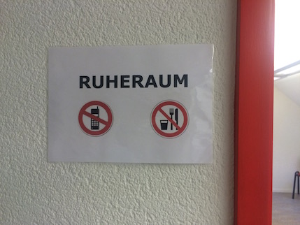 Cartell on es llegeix Ruheraum a sobre de les icones de prohibit fer servir el mòbil i prohibit menjar.